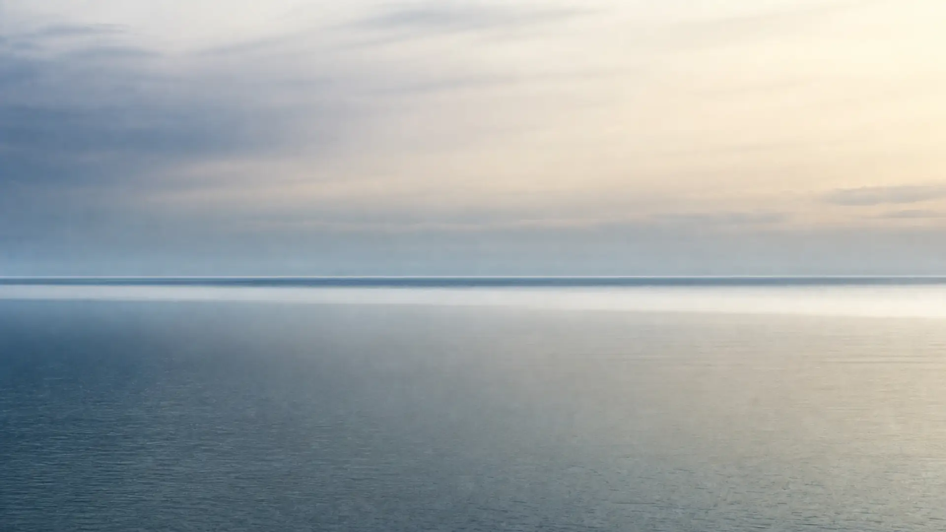A calm blue horizon under pale light after rain