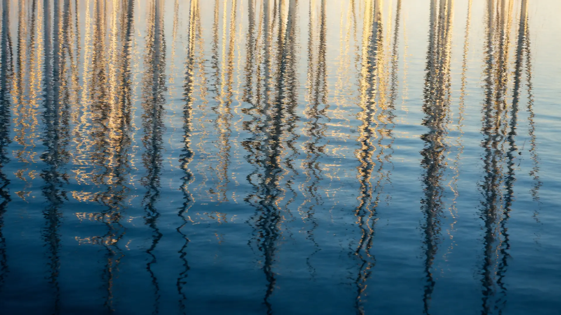 Indigo and sand-colored reflections moving across blue water